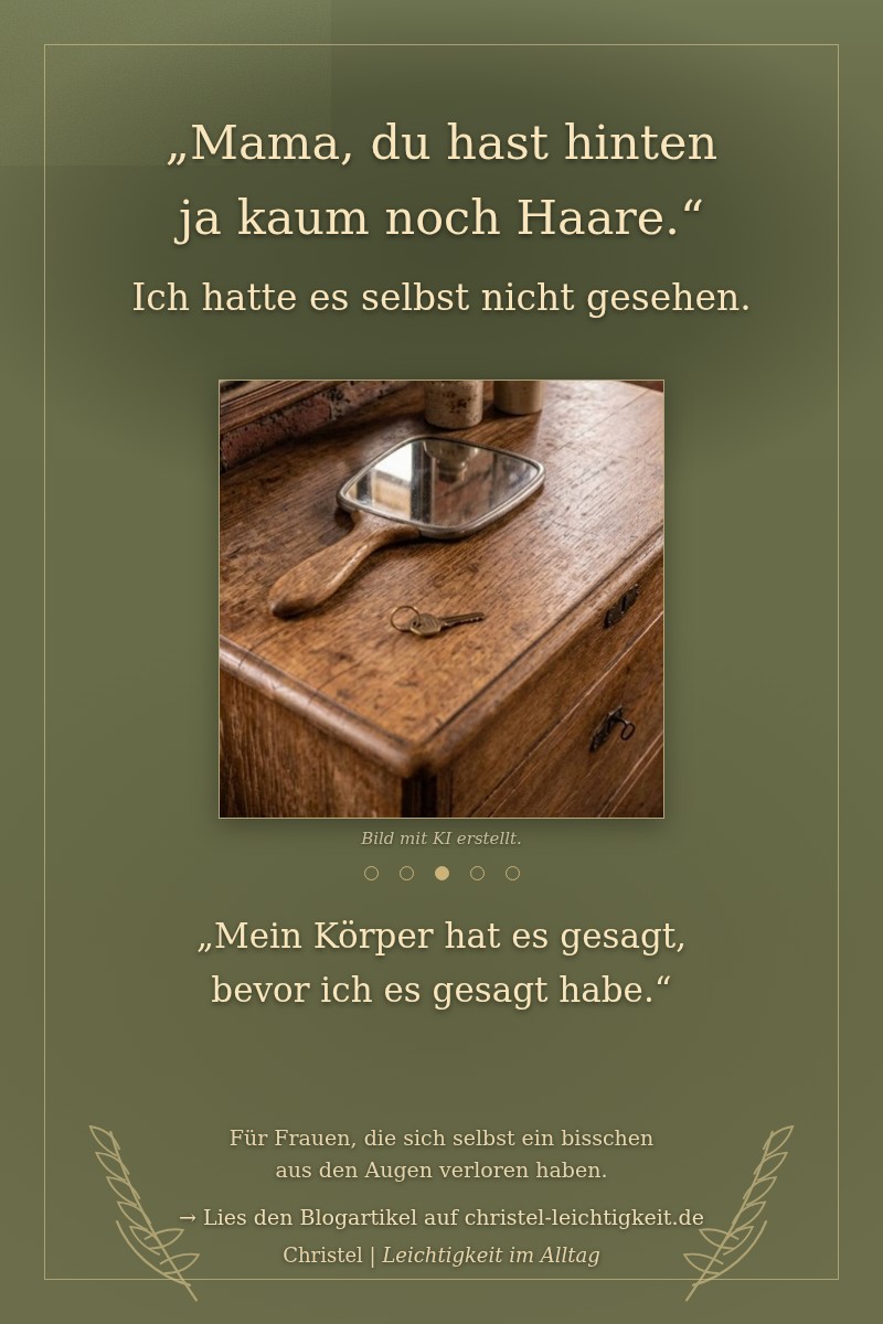 Ein alter Handspiegel mit Holzgriff liegt auf einer Kommode vor einem Wandspiegel